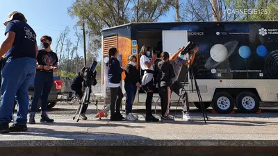 Students peer through a telescope when LabMovile comes to town.