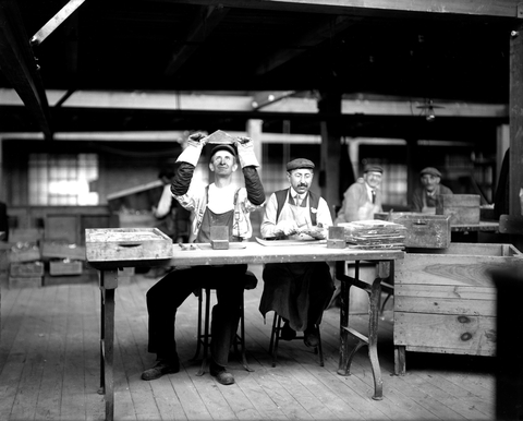 Two men inspect glass plates at the Bausch and Lomb Optical Co., Rochester, NY.