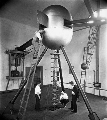 Odd Dahl (on ladder), Calvin F. Brown, Lawrence R. Hafstad, and Merle A. Tuve with two-meter electrostatic generator and cascade high-voltage tube.