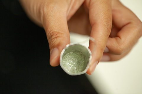 A small silver bucket filled with what looks like glass is the result of a drop quench experiment. 