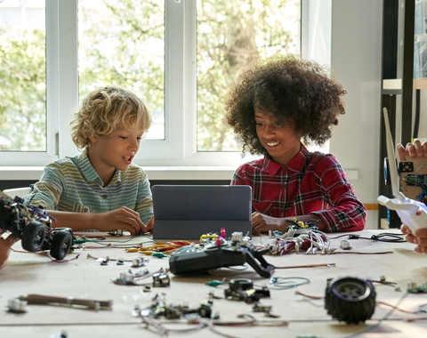 Group of five young students around a table