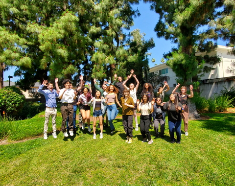 CASSI 2023 interns jump on the grass at the Observatories campus. 