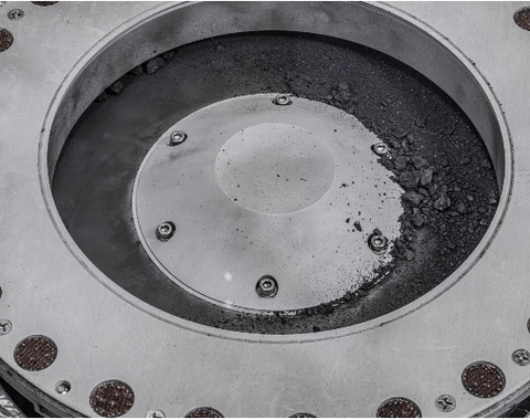 A view of the outside of the OSIRIS-REx sample collector. Sample material from asteroid Bennu can be seen on the middle right. Scientists have found evidence of both carbon and water in initial analysis of this material. The bulk of the sample is located inside. Photo: NASA/Erika Blumenfeld & Joseph Aebersold