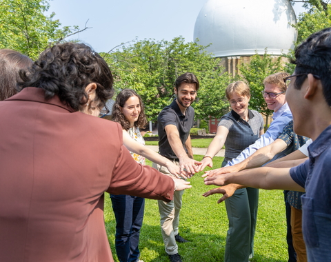 Interns hold hands in before cheering "Science!" 