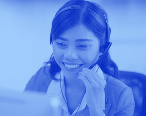 A woman answers the phone at a larger helpdesk.