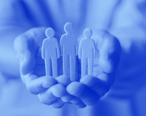 hands holding wooden people - blue