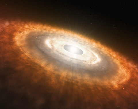 This is an artist’s impression of a young star surrounded by a protoplanetary disk in which planets are forming.   An international team of astronomers have used NASA’s James Webb Space Telescope to provide the first observation of water and other molecules in the highly irradiated inner, terrestrial-planet forming regions of a disk in one of the most extreme environments in our galaxy. These results suggest that the conditions for rocky-planet formation, typically found in the disks of low-mass star-formin