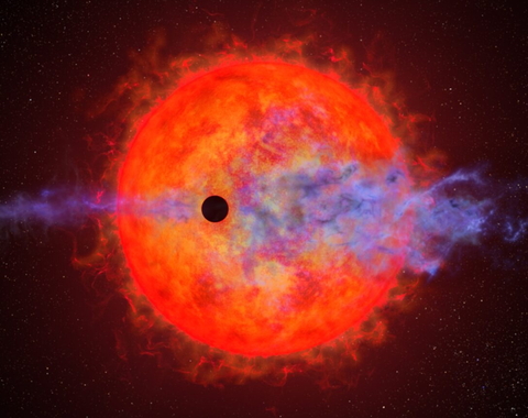 This artist's illustration shows a planet (dark silhouette) passing in front of the red dwarf star AU Microscopii. The planet is so close to the eruptive star a ferocious blast of stellar wind and blistering ultraviolet radiation is heating the planet's hydrogen atmosphere, causing it to escape into space. Credit:  NASA, ESA, and Joseph Olmsted (STScI)