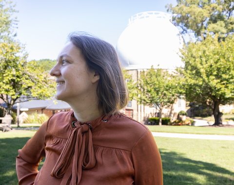 Marion Le Voyer looks to the left in front of the Atomic Physics Observatory