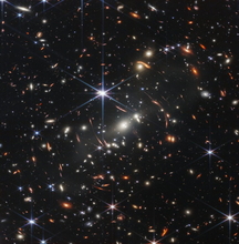 JWST Image of a foreground cluster gravitationally lensing background galaxies.