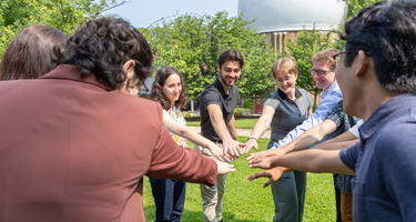 Interns hold hands in before cheering "Science!" 