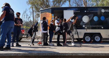 Students peer through a telescope when LabMovile comes to town.