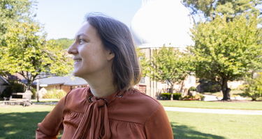 Marion Le Voyer looks to the left in front of the Atomic Physics Observatory