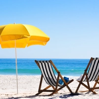 Two lounge chairs and a beach umbrella