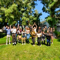 CASSI 2023 interns jump on the grass at the Observatories campus. 