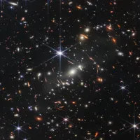 JWST Image of a foreground cluster gravitationally lensing background galaxies.