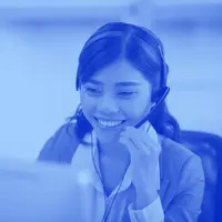 A woman answers the phone at a larger helpdesk.