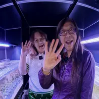 Natasha & Yixian wave at the camera after discussing coral symbiosis