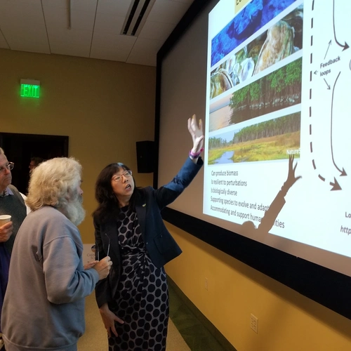 Dr Yixian Zheng Explains Biological Systems to Enthusiastic Neigbhors.jpeg