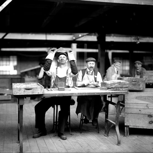 Two men inspect glass plates at the Bausch and Lomb Optical Co., Rochester, NY.