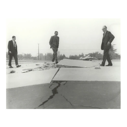 Charles Richter and others viewing buckled pavement.