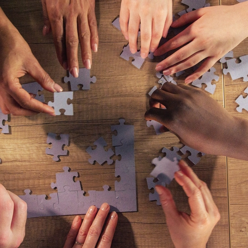 Diverse hands assemble a puzzle