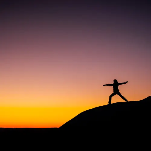 A person doing yoga at sunset.