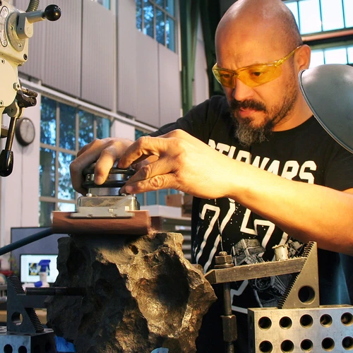 Machinist Jerson Castillo takes a turn at finishing the surface of the meteorite
