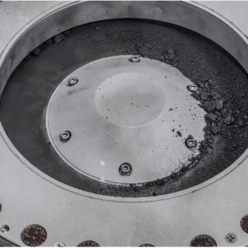 A view of the outside of the OSIRIS-REx sample collector. Sample material from asteroid Bennu can be seen on the middle right. Scientists have found evidence of both carbon and water in initial analysis of this material. The bulk of the sample is located inside. Photo: NASA/Erika Blumenfeld & Joseph Aebersold