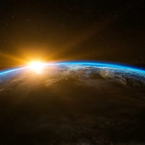 The sun shines on the horizon of Earth, as viewed from space. 
