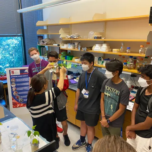 Huiqiao Pan talks to students about soybeans for a BioEYES outreach activity
