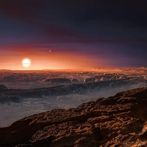 This artist’s impression shows a view of the surface of the planet Proxima b orbiting the red dwarf star Proxima Centauri, the closest star to the Solar System.  Credit: ESO/M. Kornmesser