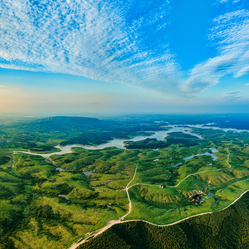 An aerial view of mountains and ocean with the sky in transition