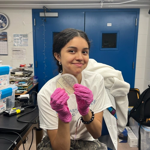 Veronica showing off her competent E.coli cells that she streaked onto an agar plate petri dish