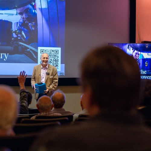 Director Mike Walter tosses a microphone box to an audience member. 
